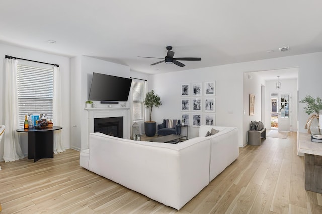 living room with ceiling fan, a healthy amount of sunlight, and light wood-type flooring