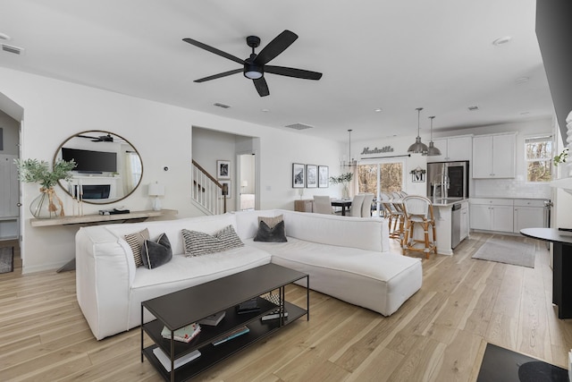 living room featuring ceiling fan and light hardwood / wood-style floors