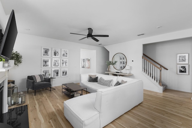 living room featuring light hardwood / wood-style flooring and ceiling fan