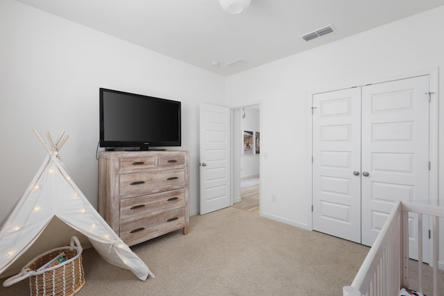 bedroom featuring a closet and light colored carpet