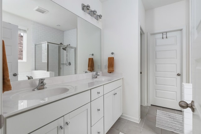 bathroom featuring tile patterned flooring, vanity, and walk in shower