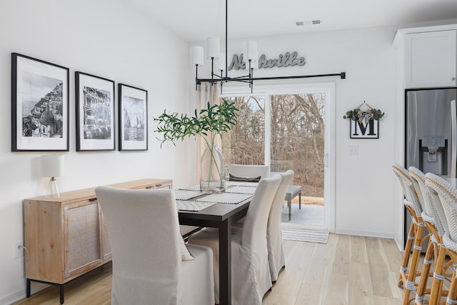 dining room featuring light hardwood / wood-style flooring and an inviting chandelier