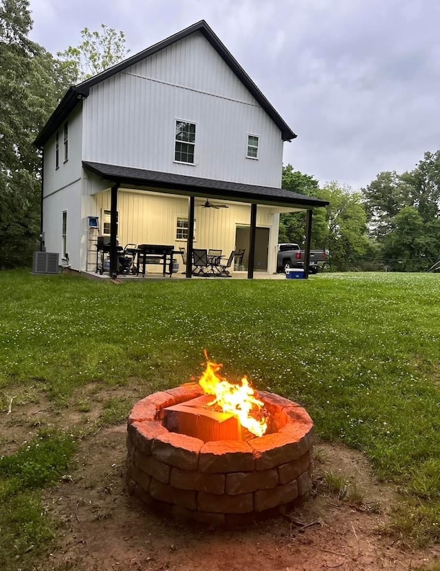 view of outbuilding with a lawn and a fire pit