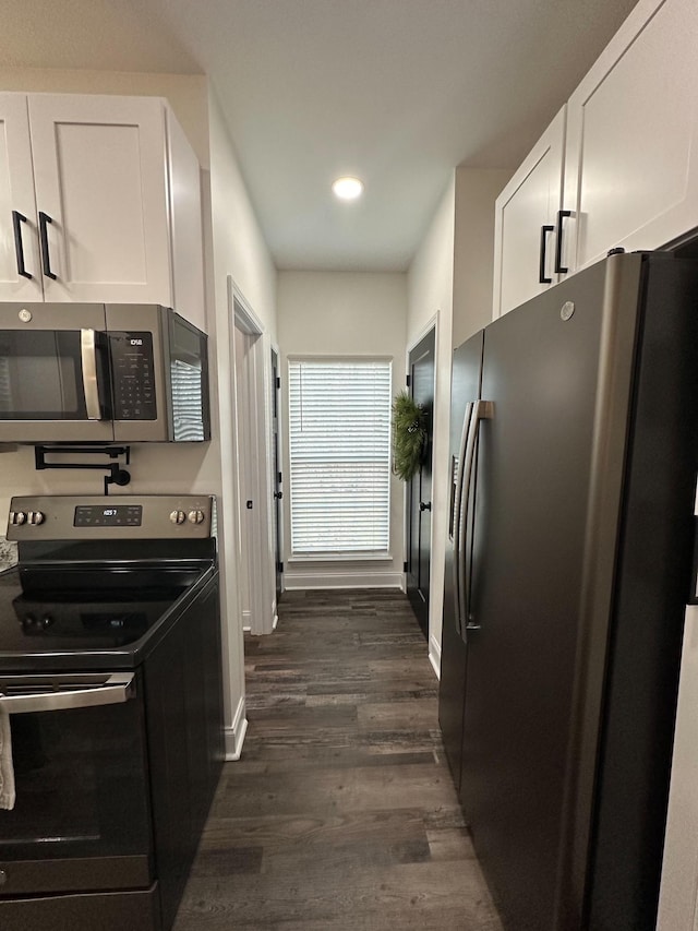 kitchen with white cabinets, dark hardwood / wood-style floors, and appliances with stainless steel finishes