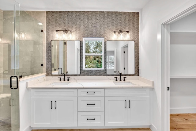 bathroom featuring hardwood / wood-style flooring, vanity, and a shower with shower door