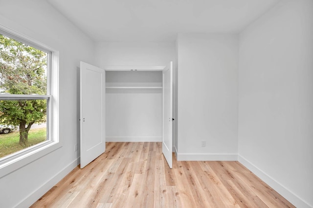 unfurnished bedroom featuring light hardwood / wood-style flooring and a closet