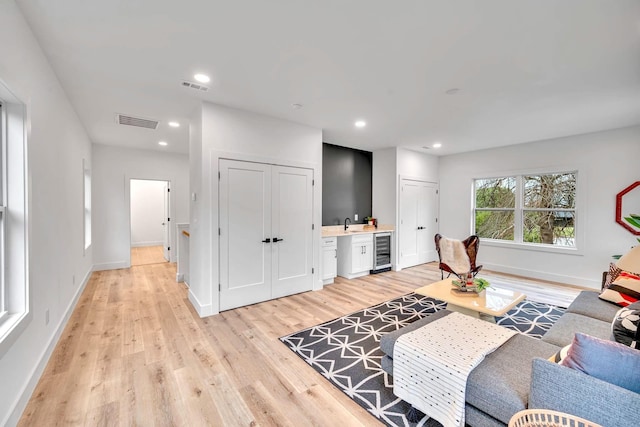 living room with light hardwood / wood-style floors and wine cooler