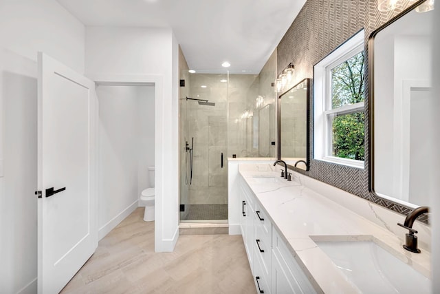 bathroom with vanity, a shower with shower door, and toilet