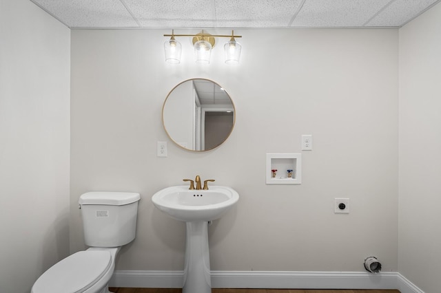 bathroom featuring a paneled ceiling and toilet