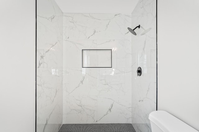 bathroom with toilet and a tile shower