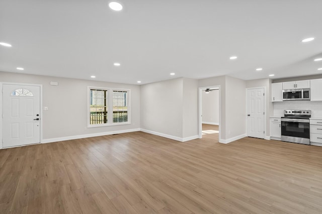 unfurnished living room featuring ceiling fan and light hardwood / wood-style flooring