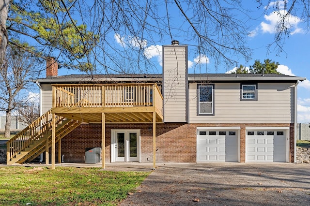 back of property featuring a garage and a deck