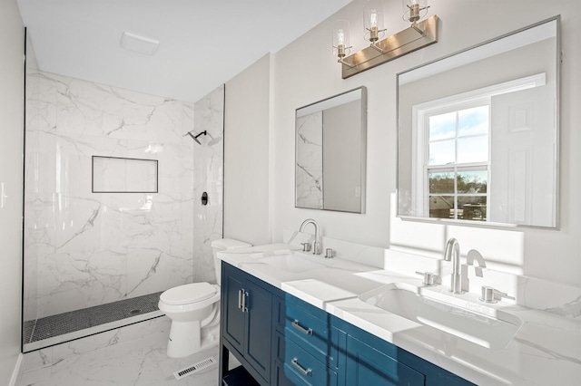 bathroom with toilet, vanity, and tiled shower