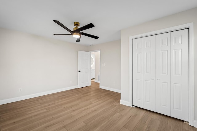 unfurnished bedroom with ceiling fan, a closet, and light wood-type flooring