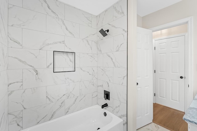 bathroom featuring tiled shower / bath combo and wood-type flooring