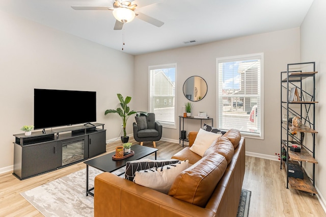 living room featuring ceiling fan and light hardwood / wood-style floors