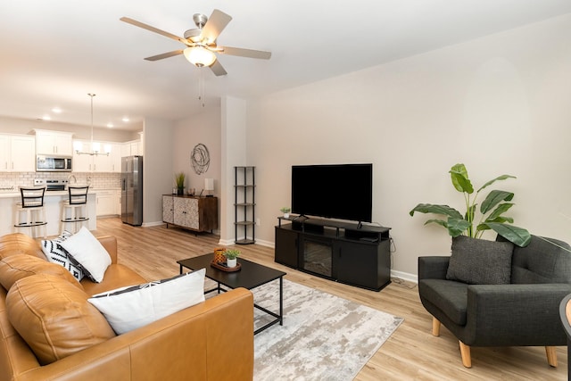 living room with ceiling fan and light wood-type flooring