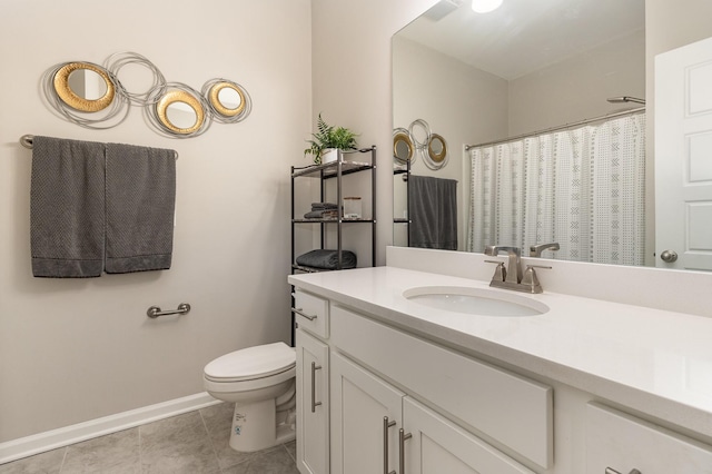 bathroom with toilet, vanity, and tile patterned floors