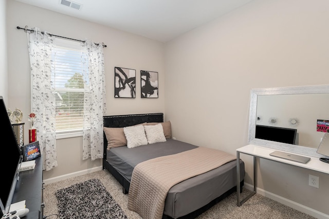 bedroom with light colored carpet and multiple windows