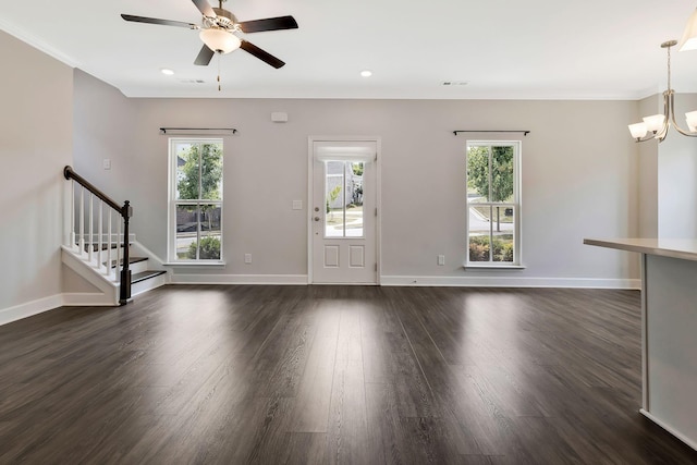 unfurnished living room featuring plenty of natural light, dark wood-type flooring, and ceiling fan with notable chandelier