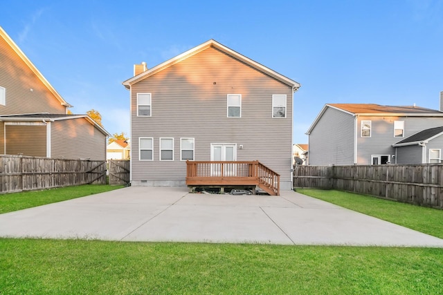 rear view of property featuring a wooden deck, a yard, and a patio