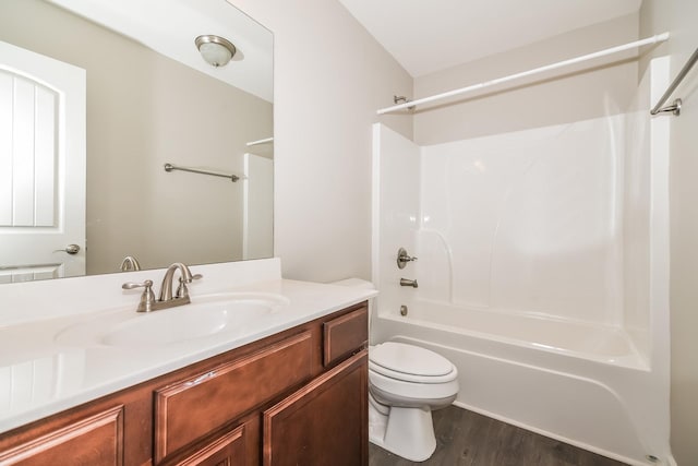 full bathroom with hardwood / wood-style flooring, vanity,  shower combination, and toilet