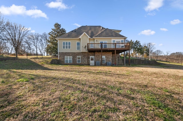 back of house with central air condition unit, a wooden deck, and a yard