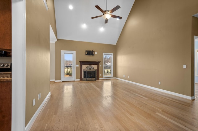 unfurnished living room with ceiling fan, high vaulted ceiling, and light hardwood / wood-style floors