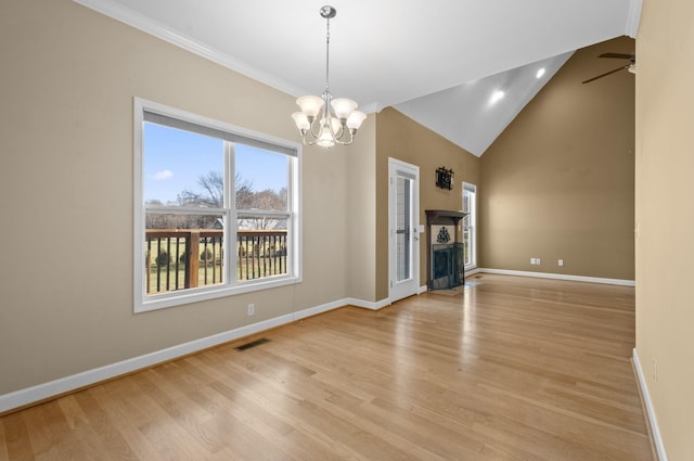 unfurnished living room featuring ceiling fan with notable chandelier, lofted ceiling, and light wood-type flooring