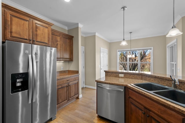 kitchen with a chandelier, appliances with stainless steel finishes, pendant lighting, and sink