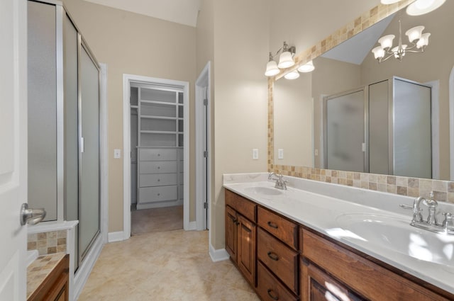 bathroom with vanity, walk in shower, and an inviting chandelier