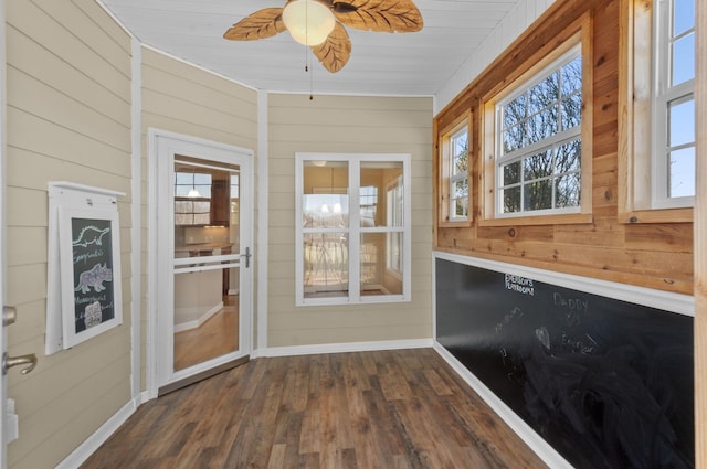 unfurnished sunroom with ceiling fan