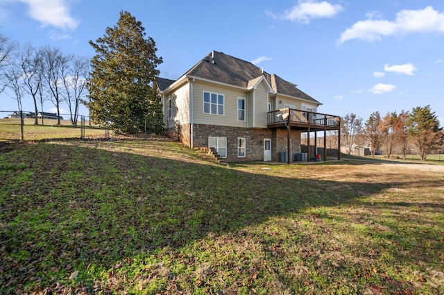 rear view of house with a yard, cooling unit, and a wooden deck