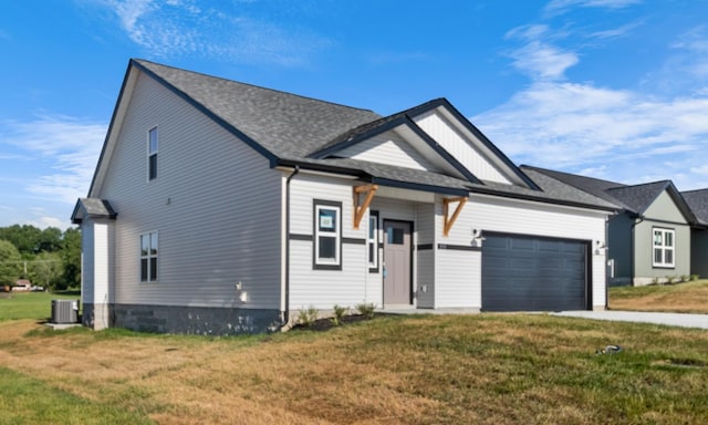 view of front of property featuring cooling unit, a front yard, and a garage