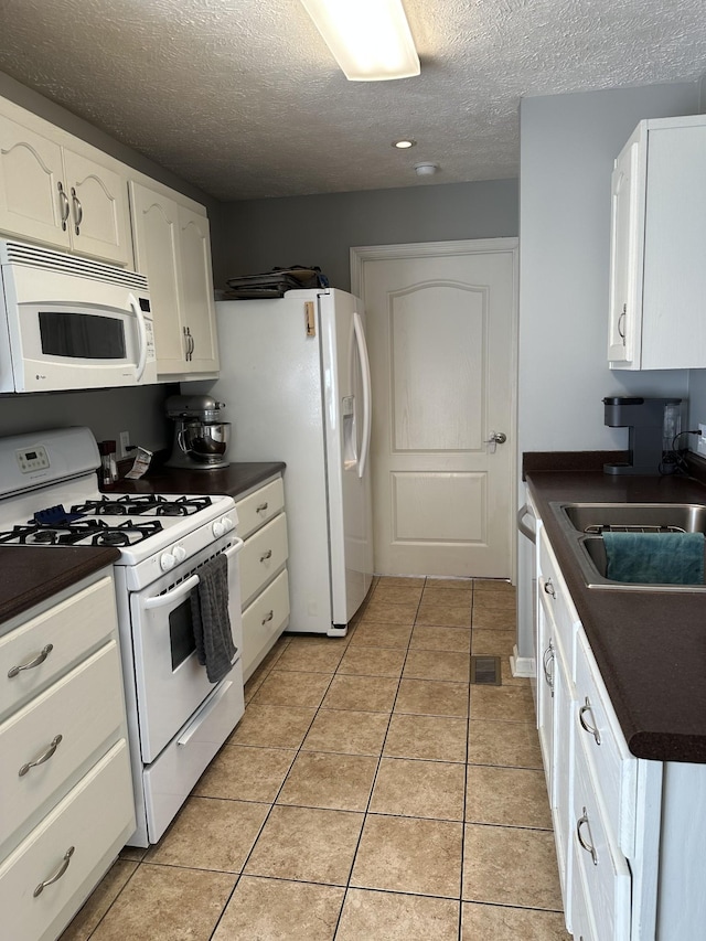 kitchen with white cabinetry, light tile patterned flooring, white appliances, and sink