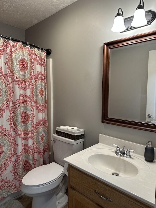 bathroom with vanity, a textured ceiling, and toilet