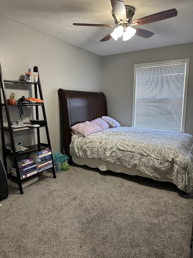 carpeted bedroom with ceiling fan and a textured ceiling