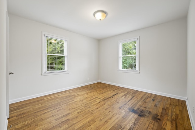 unfurnished room with hardwood / wood-style flooring