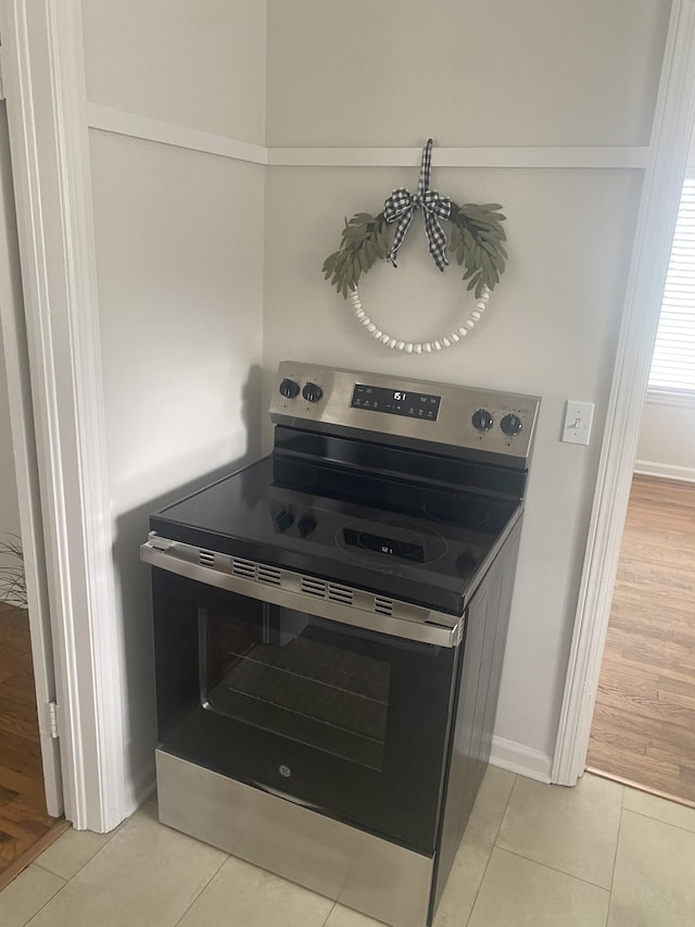 kitchen featuring stainless steel range with electric cooktop and light tile patterned flooring