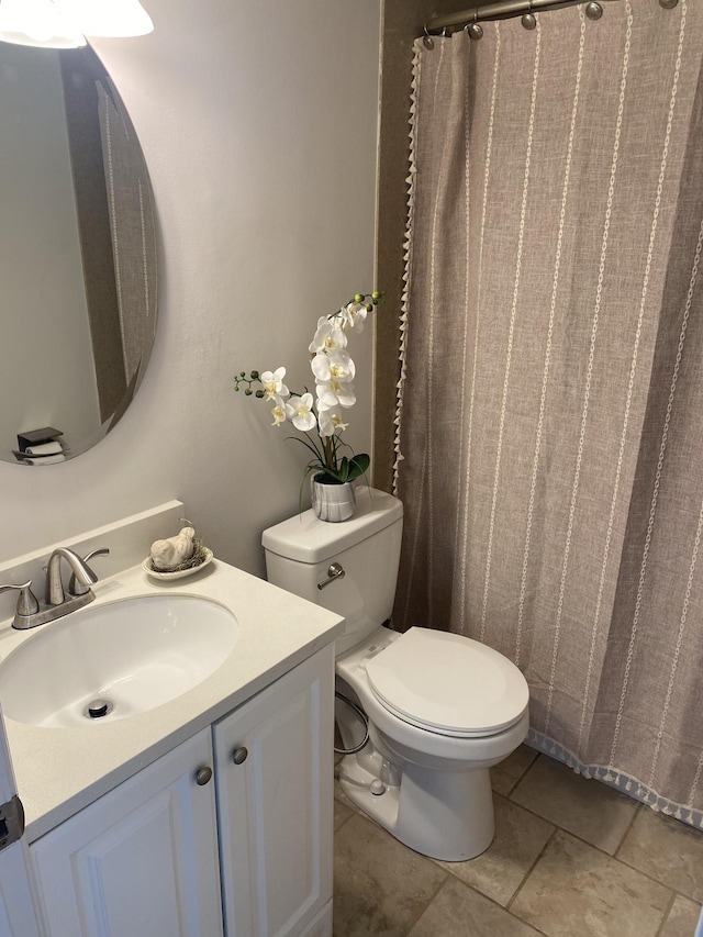 bathroom featuring tile patterned flooring, vanity, and toilet