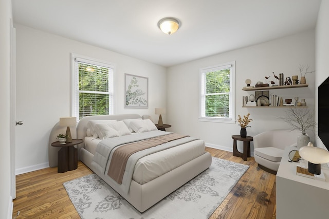 bedroom featuring multiple windows and hardwood / wood-style floors