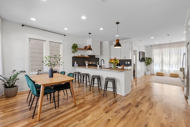 dining space with light hardwood / wood-style flooring and sink