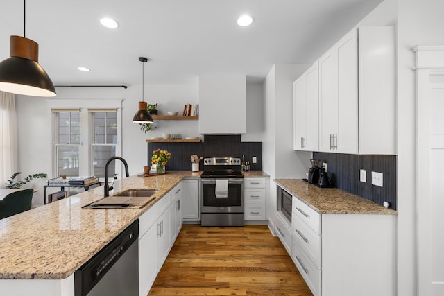 kitchen with white cabinets, decorative light fixtures, and appliances with stainless steel finishes