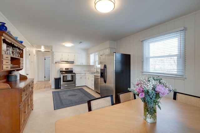 kitchen with white cabinetry, sink, ornamental molding, and appliances with stainless steel finishes