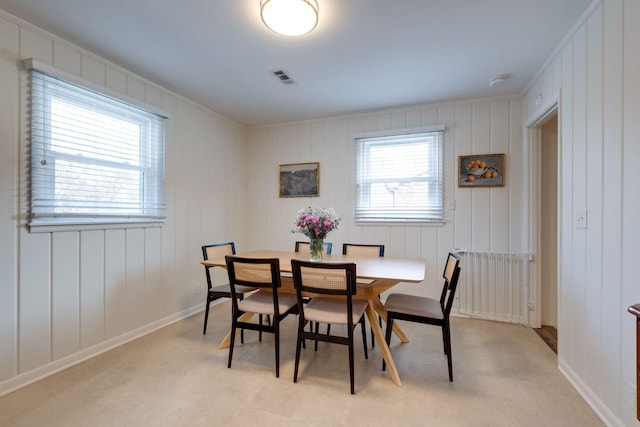 carpeted dining room with ornamental molding