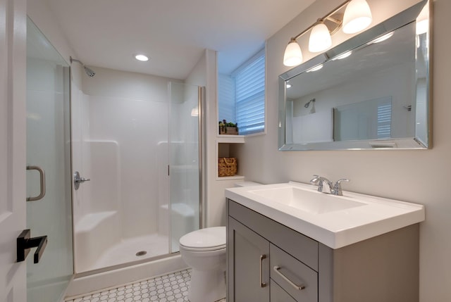 bathroom featuring tile patterned flooring, toilet, an enclosed shower, and vanity