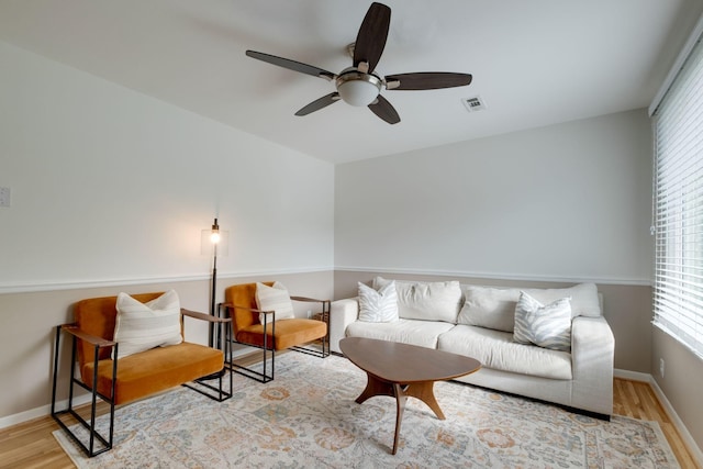 living room with light hardwood / wood-style flooring and ceiling fan