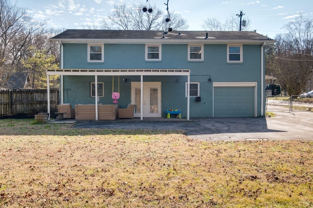 back of property featuring outdoor lounge area, a yard, and a garage