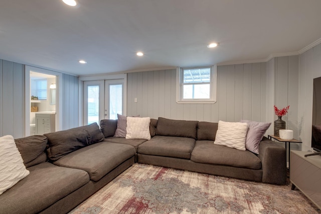 living room with wood walls, french doors, and crown molding