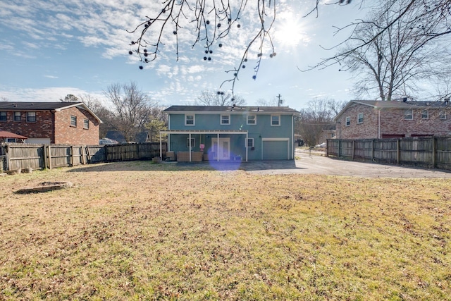 back of house with a patio area, a garage, and a yard